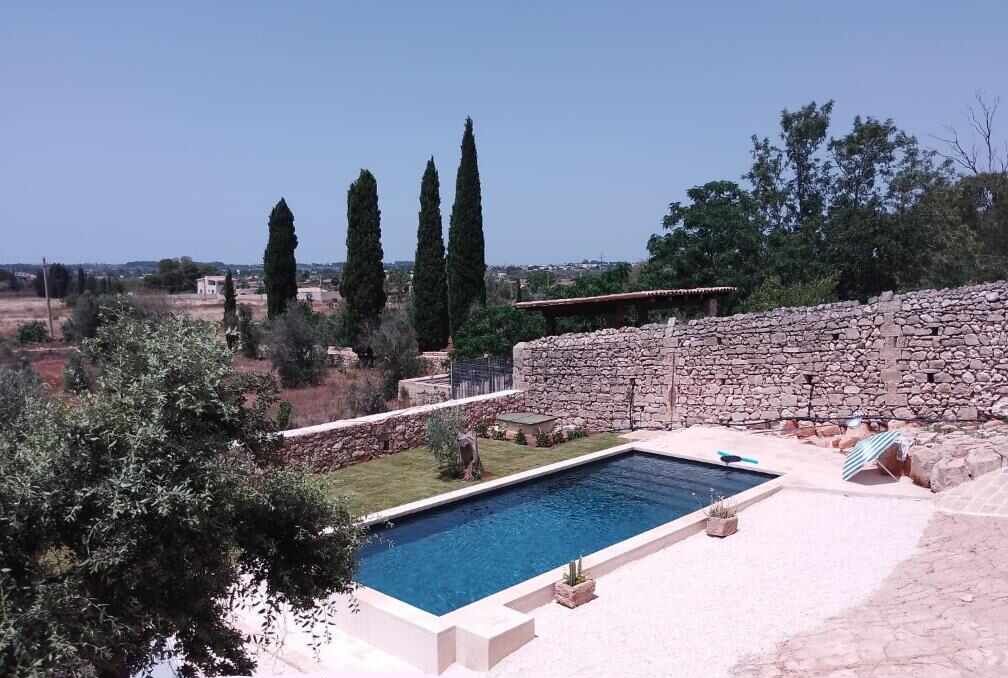 La piscina della masseria vista dall'alto, fra ulivi e muri a secco